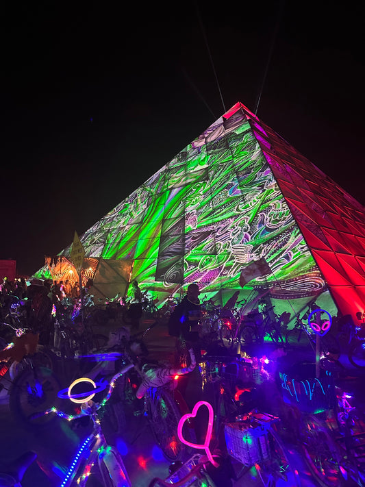 Projections of my art on a big pyramid at PlayaAlchemist Burning Man 2023 by projection artist Luma Visuals.